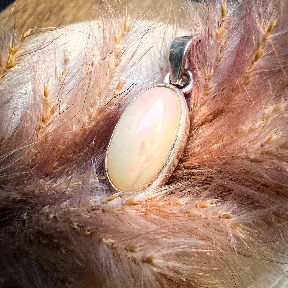 Ovaler Welo-Opal-Anhänger in sanften Pastelltönen von Rosa bis Weiß, eingefasst in eine schlichte Silberfassung, elegantes und zeitloses Schmuckstück für Damen.