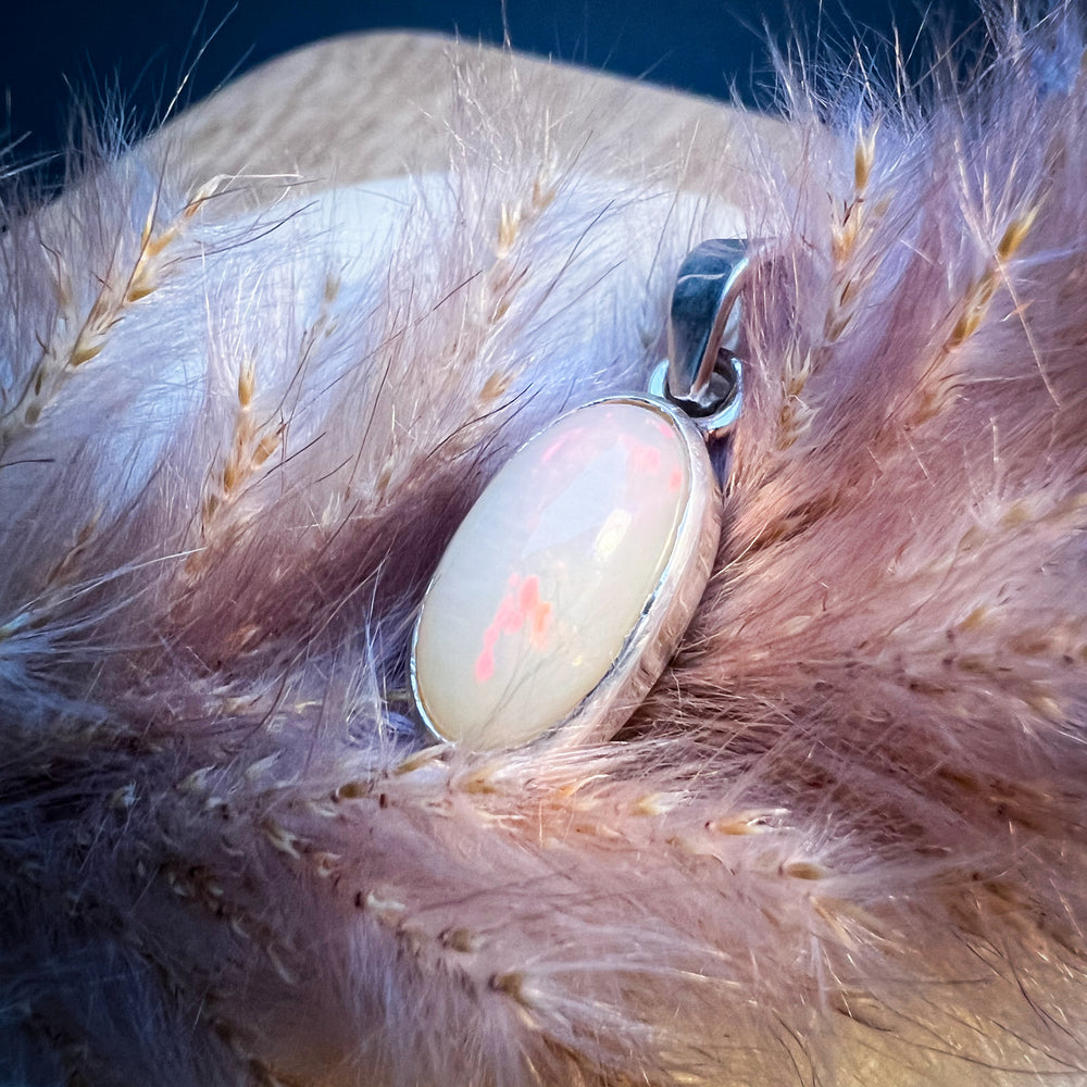 Ovaler Welo-Opal-Anhänger in sanften Pastelltönen von Rosa bis Weiß, eingefasst in eine schlichte Silberfassung, elegantes und zeitloses Schmuckstück für Damen.