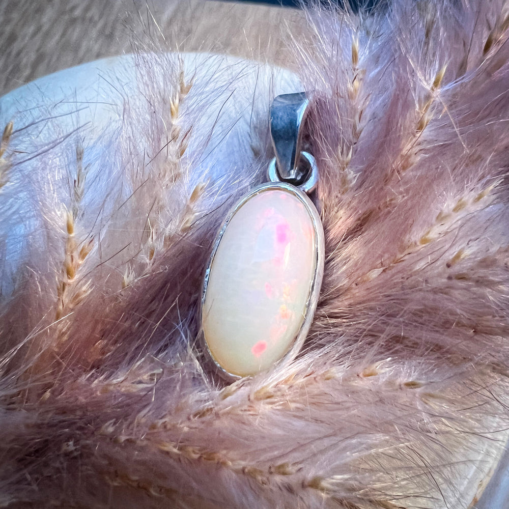 Ovaler Welo-Opal-Anhänger in sanften Pastelltönen von Rosa bis Weiß, eingefasst in eine schlichte Silberfassung, elegantes und zeitloses Schmuckstück für Damen.
