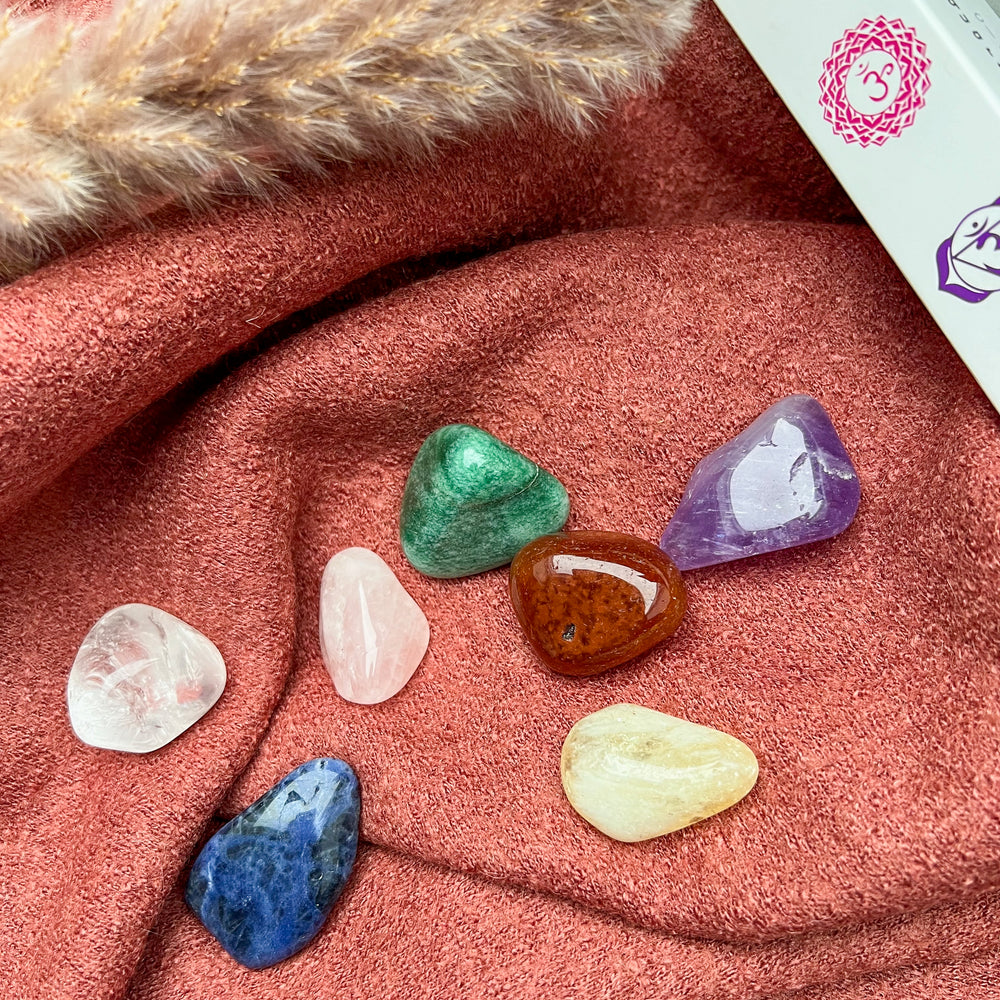 Chakra Trommelstein Set mit sieben polierten Edelsteinen in hochwertiger Verpackung, ideal für Meditation, Energiearbeit und Chakrenharmonisierung.