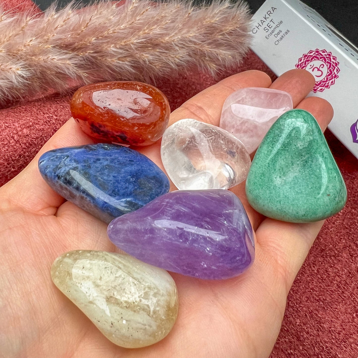 
                  
                    Chakra Trommelstein Set mit sieben polierten Edelsteinen in hochwertiger Verpackung, ideal für Meditation, Energiearbeit und Chakrenharmonisierung.
                  
                