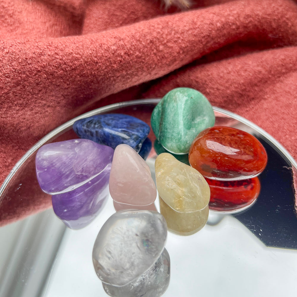 
                  
                    Chakra Trommelstein Set mit sieben polierten Edelsteinen in hochwertiger Verpackung, ideal für Meditation, Energiearbeit und Chakrenharmonisierung.
                  
                