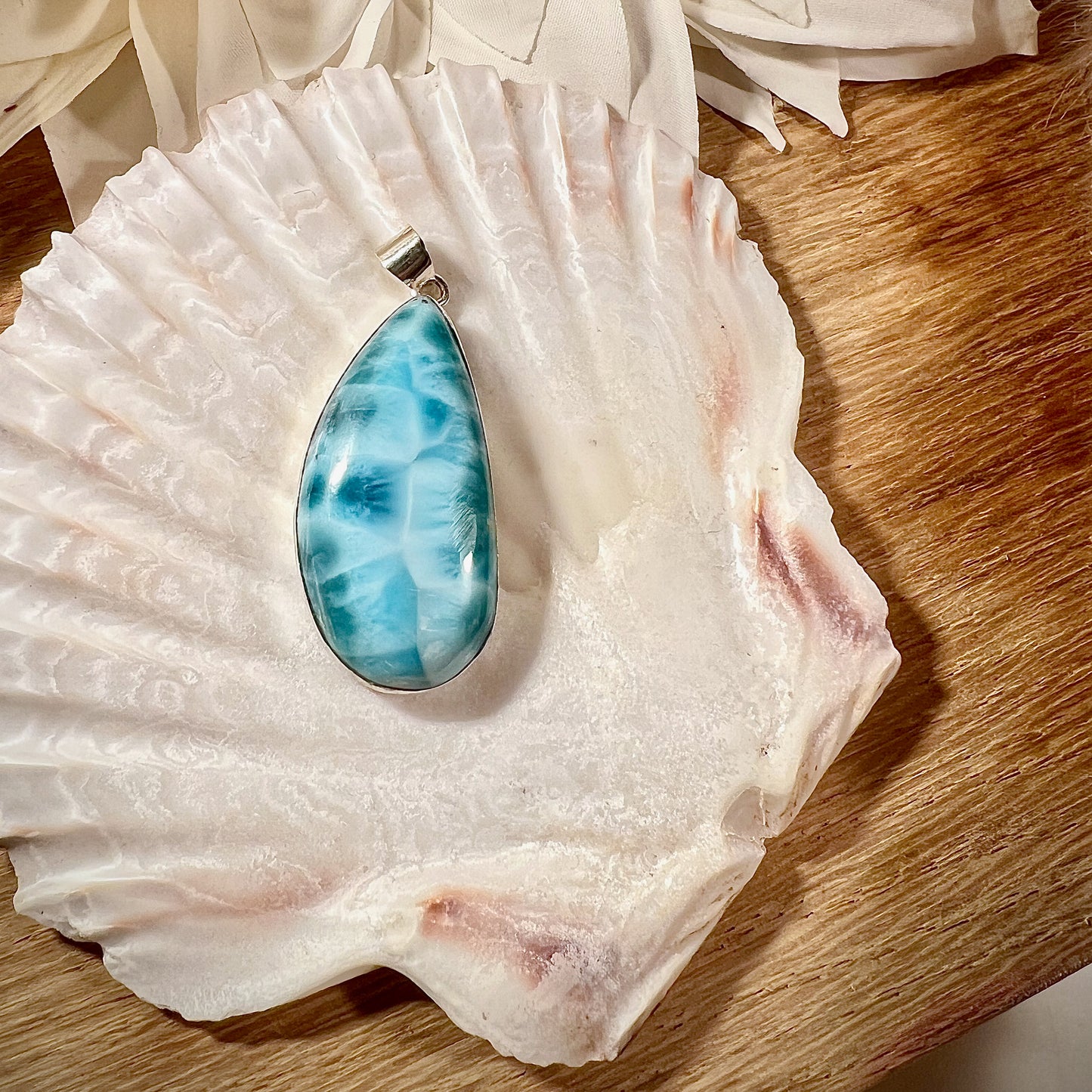 
                  
                    Eleganter Larimar-Anhänger in Tropfenform, gefasst in hochwertigem Silber, präsentiert auf einer Muschelschale. Der hellblaue Edelstein mit natürlicher Maserung wirkt beruhigend und erinnert an die Farben des Meeres. Ideal als einzigartiges Schmuckstück für spirituelle und modebewusste Träger. Hochwertiger Larimar-Anhänger für Damen, perfekt als Geschenk oder für besondere Anlässe.
                  
                