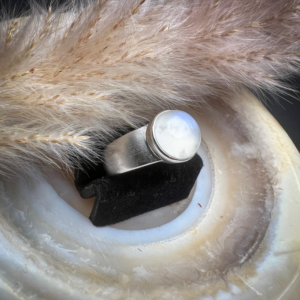Breiter Silberring mit natürlichem ovalem Mondstein, geheimnisvoll schimmernde Blau- und Weißtöne, elegantes und zeitloses Schmuckdesign, hochwertiger Mondsteinring für Damen.